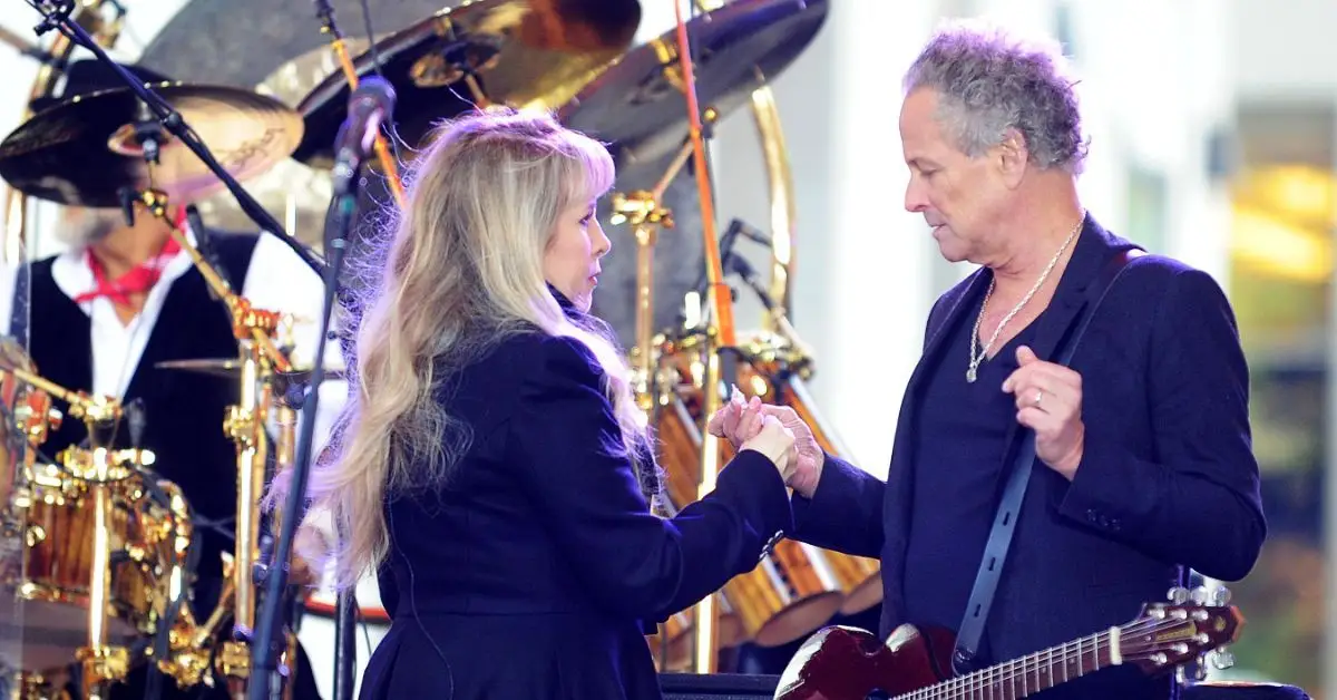 Lindsey Buckingham et Stevie Nicks se tiennent la main et se regardent tout en jouant avec Fleetwood Mac.
