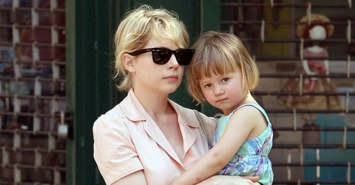 Michelle Williams marche en tenant la jeune Matilda Ledger