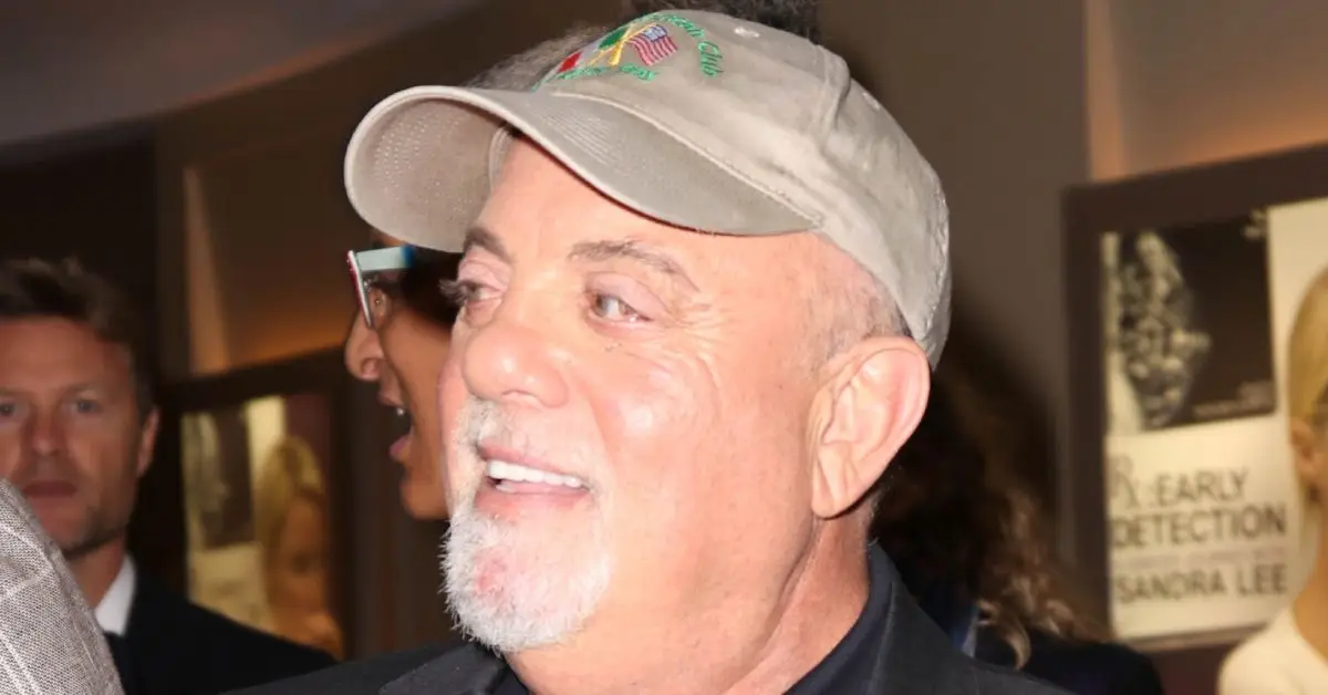 Billy Joel trägt einen Hut und lächelt bei einer Veranstaltung