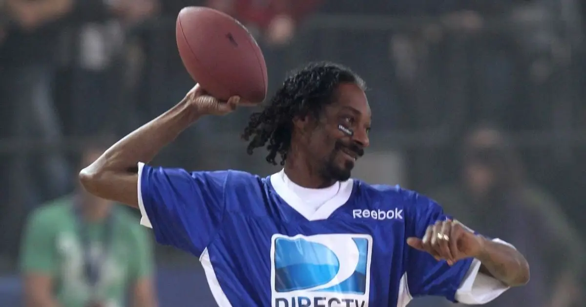 Snoop Dogg segurando uma bola de futebol