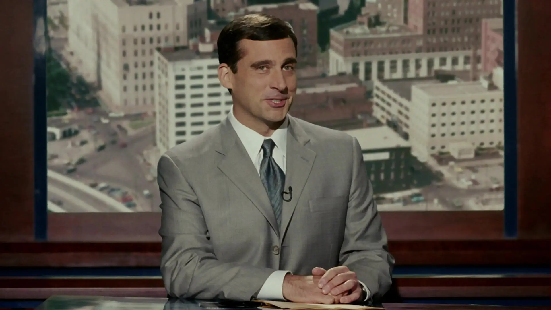 Steve Carell i rutig kostymjacka och blå skjorta ler utanför