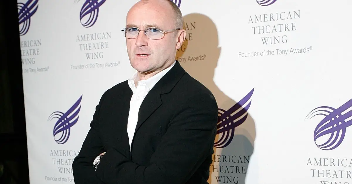 Phil Collins debout, regardant la caméra