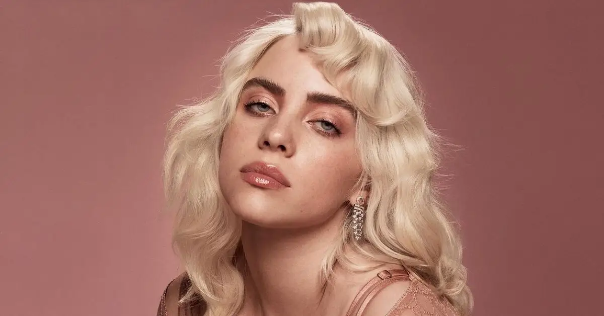 Billie Eilish mit platinblondem Haar lächelt in die Kamera