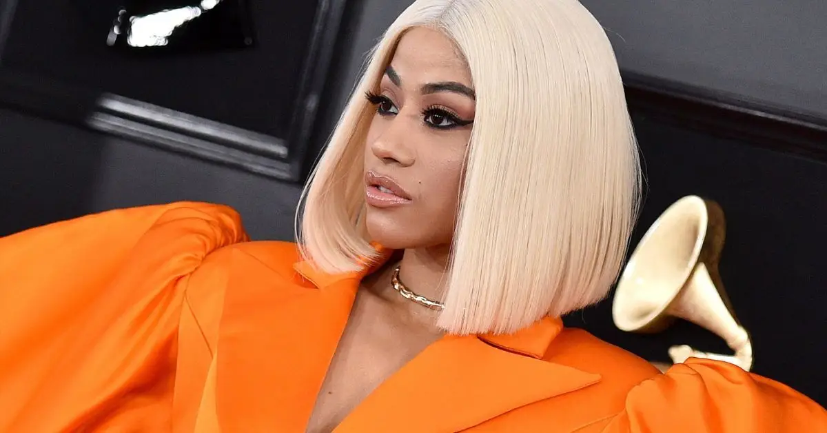 Cardi B con un elegante vestido negro (izquierda), Cardi B tocando en vivo con un atuendo que usa colores LGBTQ (derecha)