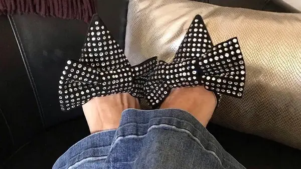 A person wearing embellished mules