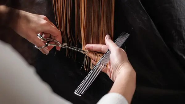 Stylist using sheers to cut hair
