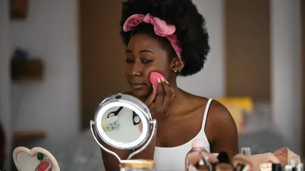A woman applying foundation with a sponge