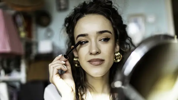 Woman applies mascara