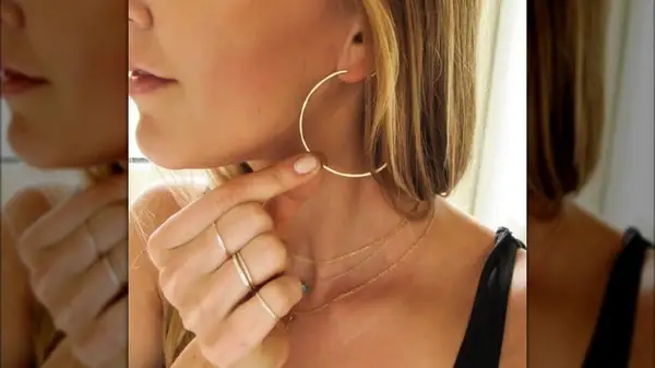 A close up of a thin golden hoop in a woman