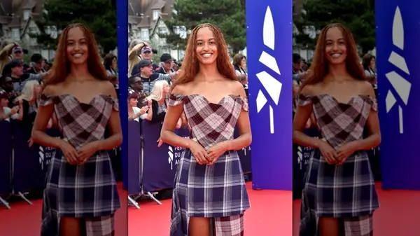Malia Obama standing on the red carpet in a plaid dress