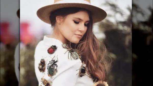 Woman wearing several insect-style brooches 