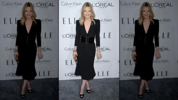 Michelle Pfeiffer wearing a black dress with a statement belt on the red carpet