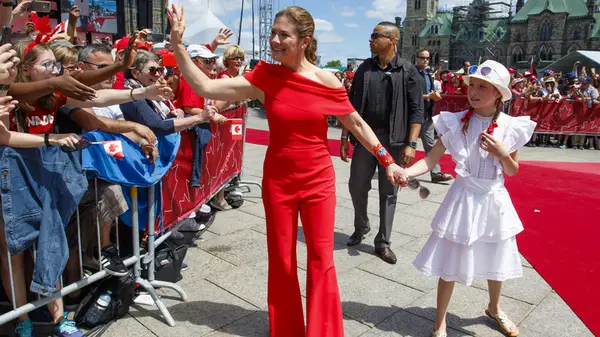 Sophie Grégoire Trudeau in a red jumpsuit and her daughter greet crowds