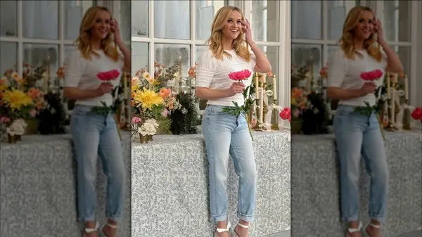 Reese Witherspoon in light wash denim and a white shirt holding a flower