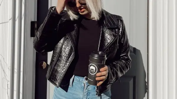 woman posing and holding to-go cup of coffee