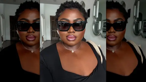 A woman with a round face wearing chunky sunglasses