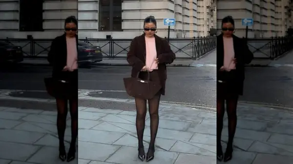 A woman on the street wearing an all-brown outfit with a light pink shirt