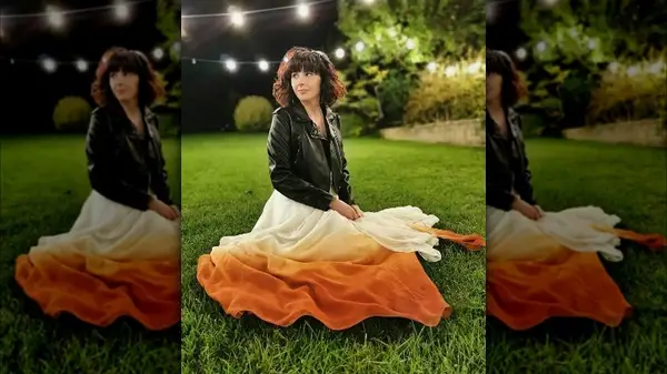Woman wearing colorful wedding dress in grass