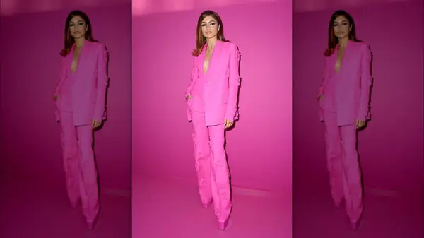 Zendaya posing against a pink background at Paris Fashion Week in 2022