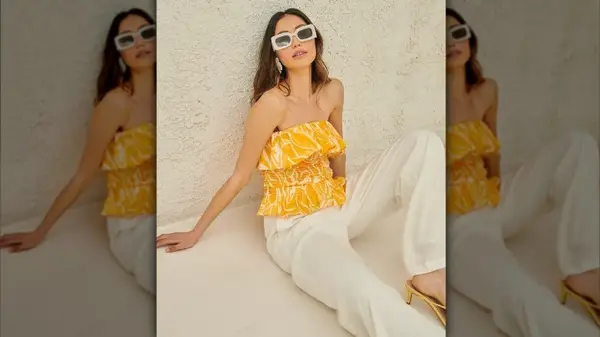 Woman in a crop top and white pants 