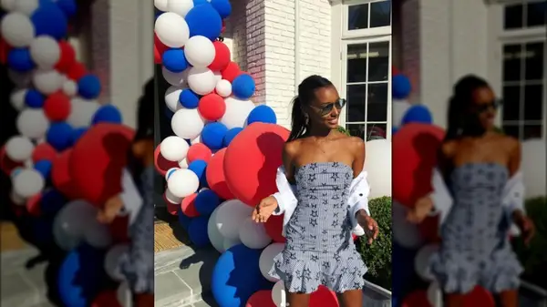 Jasmine Tookes wearing a blue mini dress with red, white and blue balloons in the background