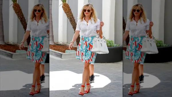 Reese Witherspoon walking in a red, while and blue outfit