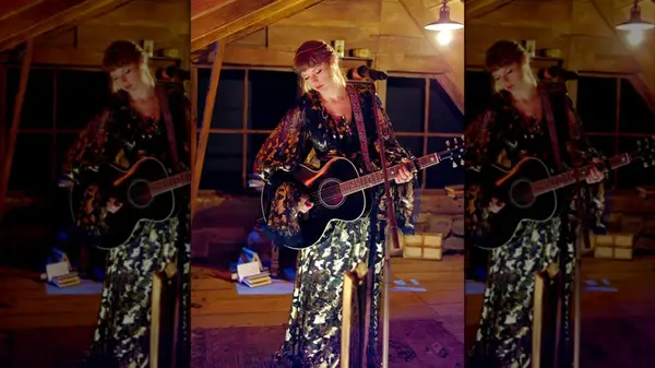 Taylor Swift on stage with a guitar