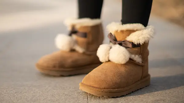 A woman wearing shearling Ugg-like boots 