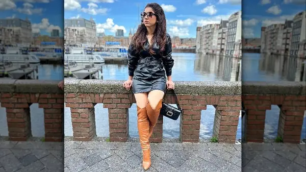 woman in black dress and brown boots