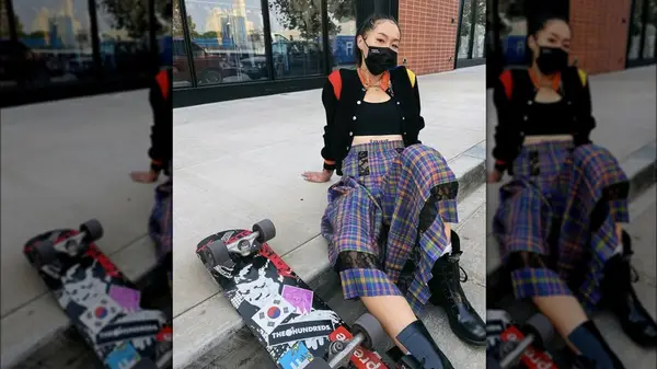 woman on sidewalk with skateboard
