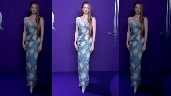 Hunter Schafer posing in a hand-painted dress at a GQ event