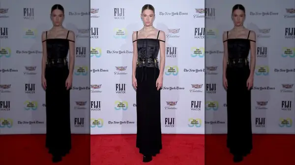 Hunter Schafer posing in a black dress with padlocks at the Gotham Awards