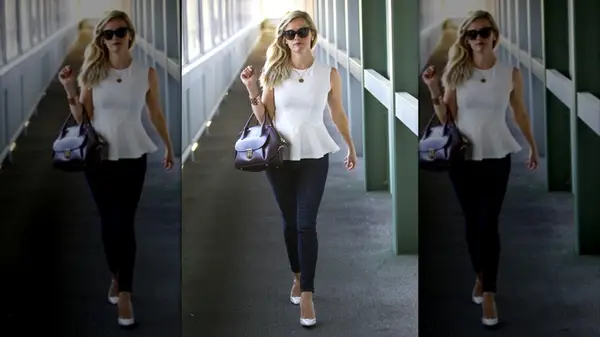 Reese Witherspoon walking down a hallway in a white top and jeans