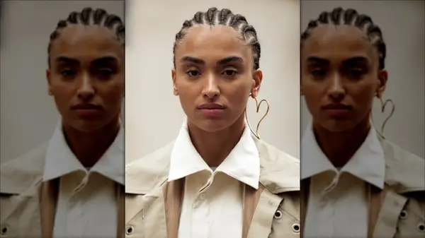 A woman with a big heart earring and a white collar shirt