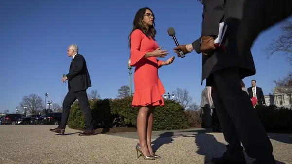 Lauren Boebert speaking to reporters in a coral dress