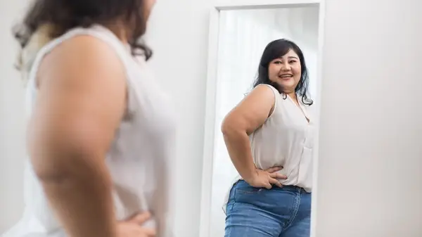 Woman admiring her outfit in the mirror