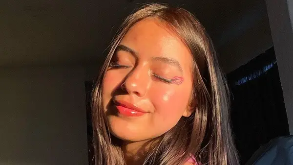 Woman smiling with heart-shaped eye makeup