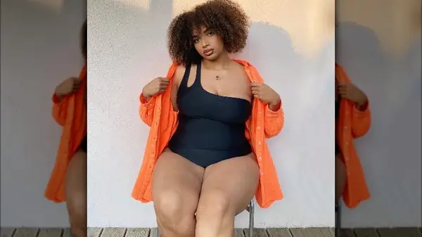 Woman wears black off-the-shoulder swimsuit