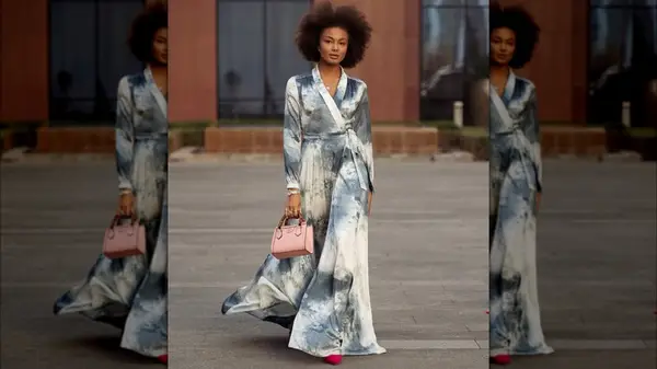 A woman in a long dress and pink bag 