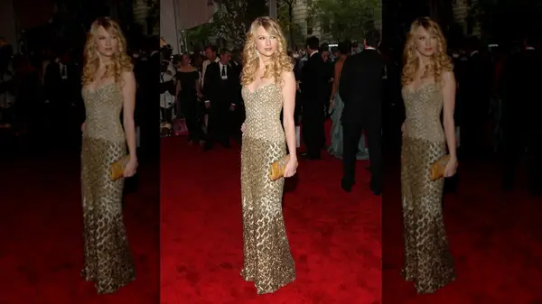 Taylor Swift on the red carpet in a gold, textured gown