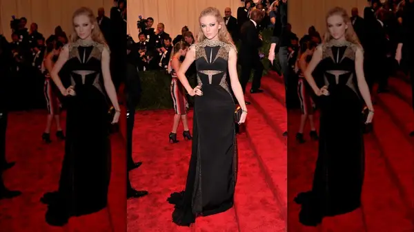 Taylor Swift on the red carpet in a black gown with lace cutouts