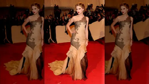 Taylor Swift on the red carpet in a pink dress with black lace accents