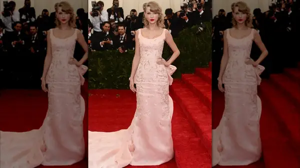 Taylor Swift on the red carpet in a pink ball gown with a long train