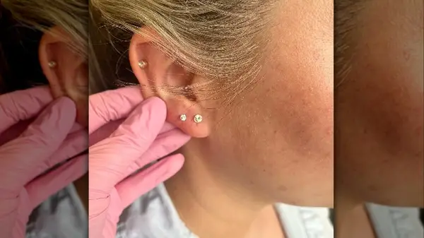 Pink glove holding ear piercings