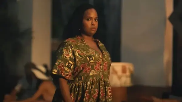 A woman walking in a long green tropical-patterned dress