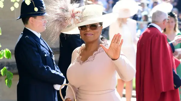 Oprah wearing a pink dress and hat