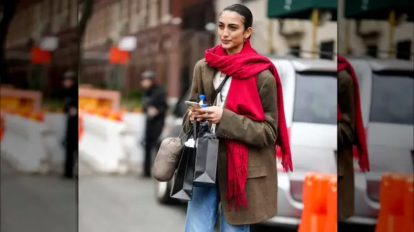 A woman in a brown blazer and a red scarf 