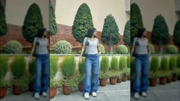 A woman with wide leg jeans and sneakers in a garden