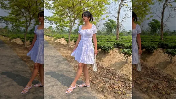 Woman wearing a white, milkmaid-style dress in an outdoor setting