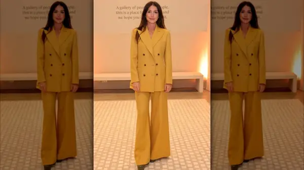 Katy Hessel poses in flared pantsuit